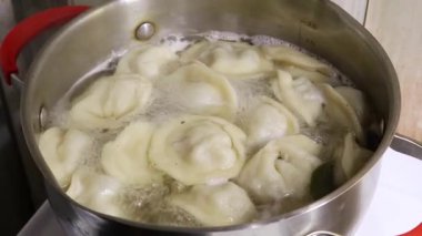 Ev yapımı hamur köftelerini kaynamış et suyunda yaprağıyla pişirmek..