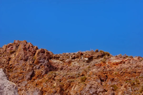 Red-grey-ochre-rocks-under-blue-sky — 图库照片