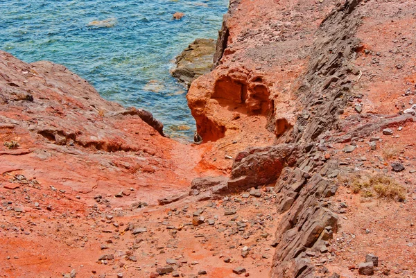 Craggy-red-rocks-and-ocean-by-Playa-Blanca — Zdjęcie stockowe
