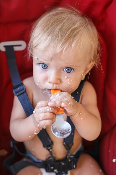 Meisje van de baby op haar eigen eten met lepel — Stockfoto