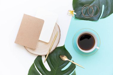 Tropik çalışma alanı konsepti. Not defteri ve tropik palmiye yaprakları. Model sunum çalışma yeri.