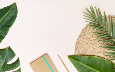 Tropik çalışma alanı konsepti. Not defteri ve tropik palmiye yaprakları. Model sunum çalışma yeri.