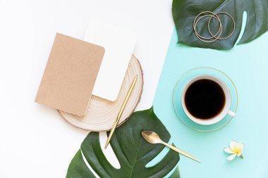 Tropik çalışma alanı konsepti. Not defteri ve tropik palmiye yaprakları. Model sunum çalışma yeri.