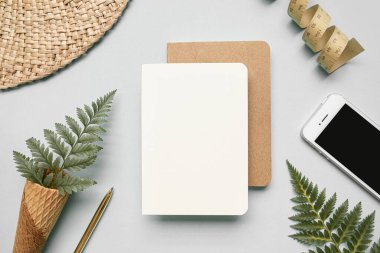 Tropik çalışma alanı konsepti. Not defteri ve tropik palmiye yaprakları. Model sunum çalışma yeri.