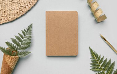 Tropik çalışma alanı konsepti. Not defteri ve tropik palmiye yaprakları. Model sunum çalışma yeri.