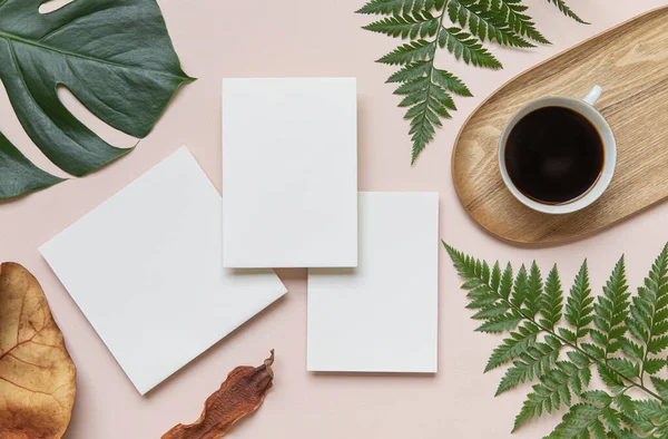 Mockup de casamento de verão estilo. Saudação em branco e cartão de convite. Folhas tropicais verdes com cartão de convite na mesa. — Fotografia de Stock