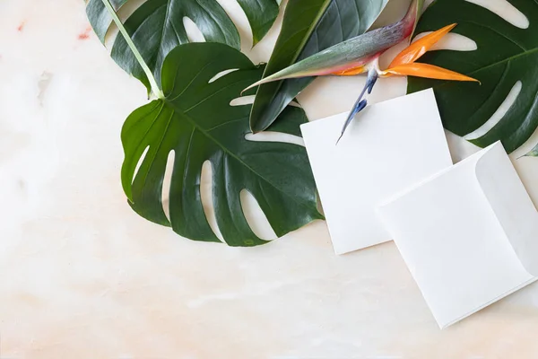 Gestileerde zomer bruiloft desktop briefpapier mockup. Blanco wens- en uitnodigingskaart. Groene tropische bladeren met lege ruimte. — Stockfoto
