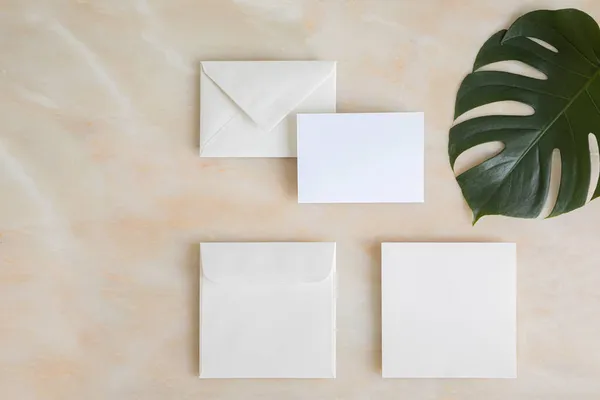 Estilo casamento de verão mockup de papelaria desktop. Saudação em branco e cartão de convite. Folhas tropicais verdes com espaço vazio. — Fotografia de Stock