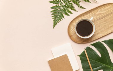 Tropik çalışma alanı konsepti. Not defteri ve tropik palmiye yaprakları. Model sunum çalışma yeri.