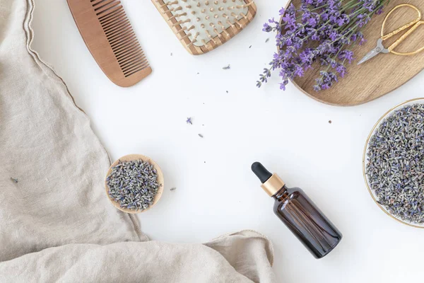 Bottiglia di ambra di olio essenziale di lavanda. Flat lay concetto di cura della pelle. Fondo chiaro con fiore di lavanda. — Foto Stock