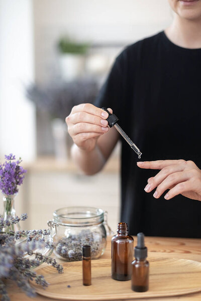 Using natural essential oil in a home spa ritual. A woman takes care of her skin and hair