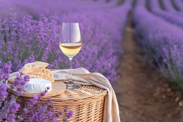 ラベンダー畑で白ワインのグラス 背景に紫色の花 — ストック写真