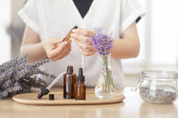 Using natural essential oil in a home spa ritual. A woman takes care of her skin and hair