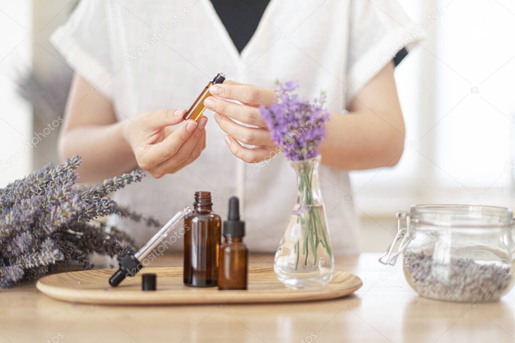 Using natural essential oil in a home spa ritual. A woman takes care of her skin and hair