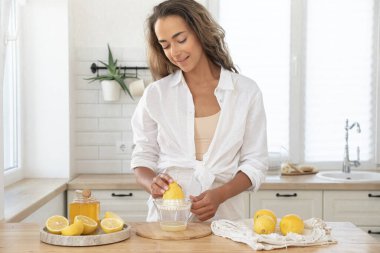 Tahta tahtada limon kesen genç bir kadın. Taze şarap hazırlığı. Lavanta ve limon