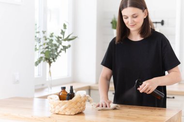 Genç bir kadın mutfağı ekolojik ürünlerle temizliyor.