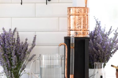 Distillation of lavender essential oil. Copper alambic in a Scandinavian interior clipart
