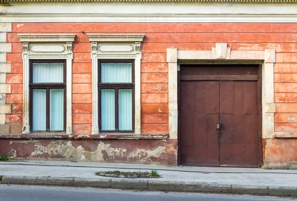 Facade of an old building with two windows and door — Stock Photo, Image