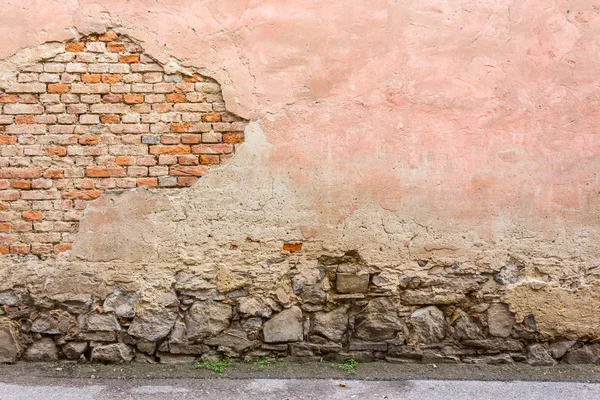 Alte rissige Mauer mit Steinsockel — Stockfoto