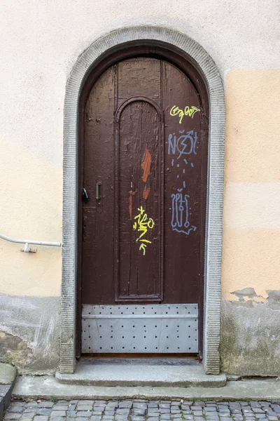 Wooden door with lock in arch on old street — Stock Photo, Image
