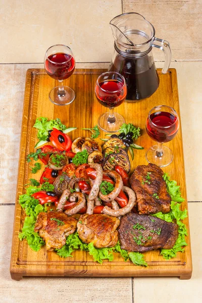 Grilled meat, sausages and herbs with wine — Stock Photo, Image