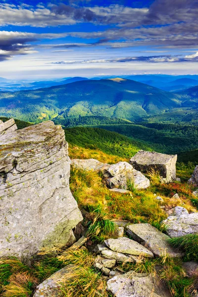 Scherpe stenen onder de verticale berglandschap van weiden — Stockfoto