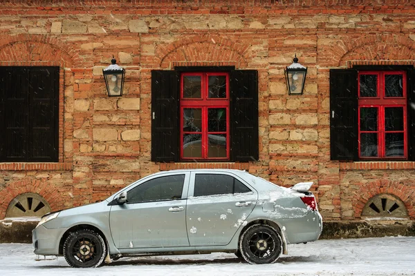 Carro esportivo perto do antigo edifício no inverno — Fotografia de Stock