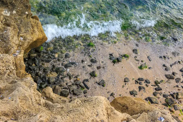 Vague roule sur les rochers de la côte sablonneuse — Photo