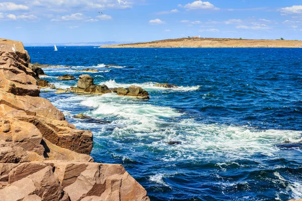 Морской пейзаж с волнами, разбивающими берег и остров — стоковое фото