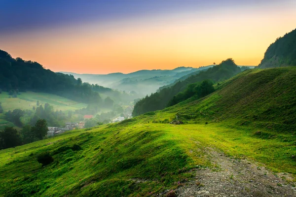 Wzgórza w pobliżu miejscowości w rannej mgle — Zdjęcie stockowe