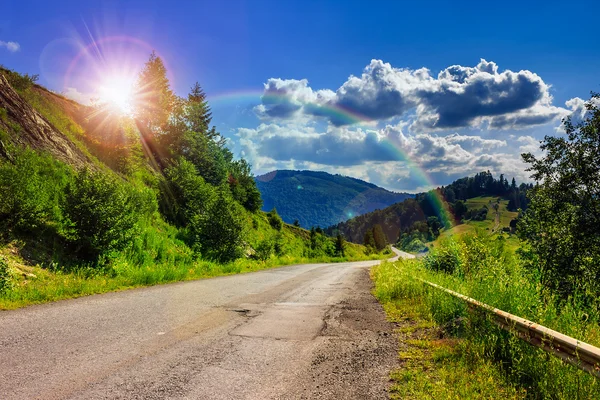 Mountain road near the coniferous forest with cloudy morning sky — Stock Photo, Image