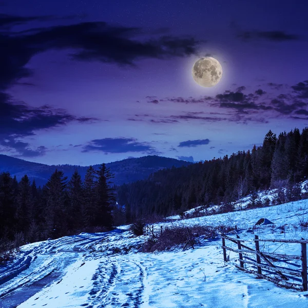 Fence by the road to snowy forest in the mountains — Stock Photo, Image