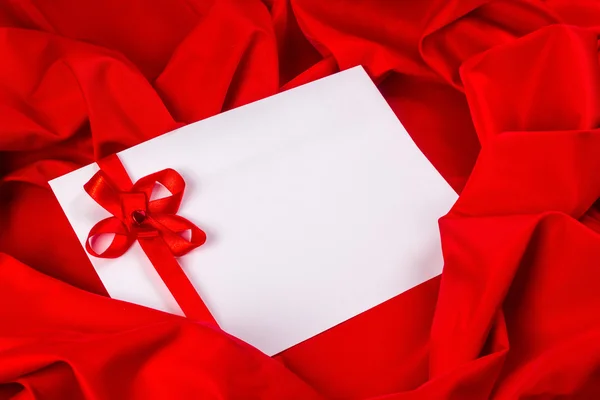 Love card with ribbon on a red fabric — Stock Photo, Image