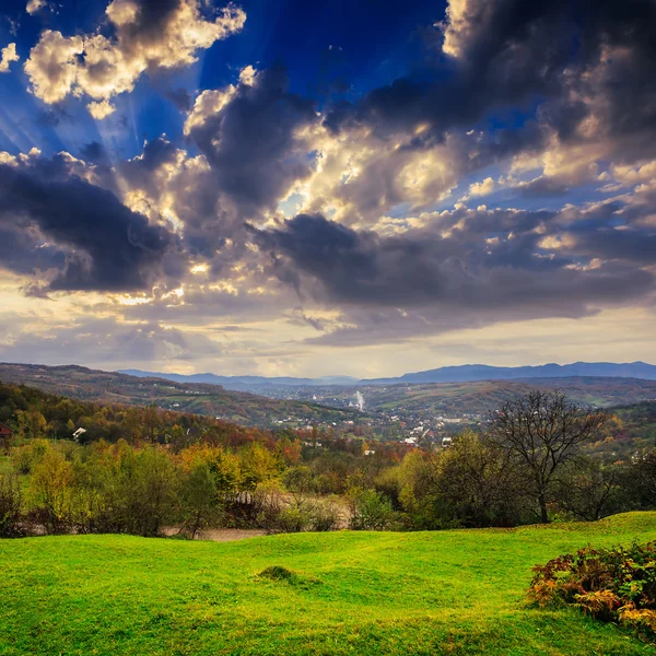 Pueblo en la ladera del prado con bosque en la montaña —  Fotos de Stock