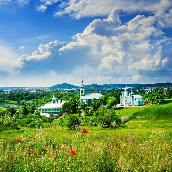 Rote Mohnblumen und das grüne Kloster — Stockfoto