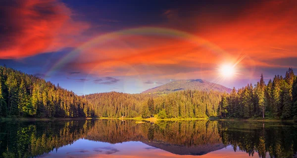 Pinède et lac près de la montagne tôt au coucher du soleil — Photo