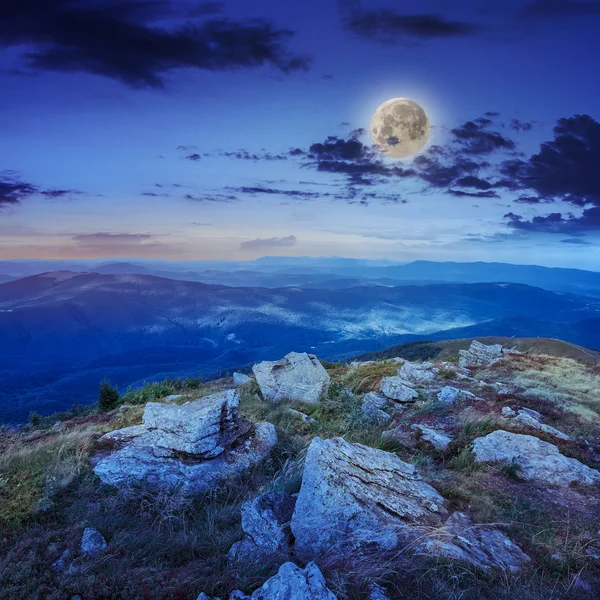 Light on stone mountain slope with forest at night — Stock Photo, Image