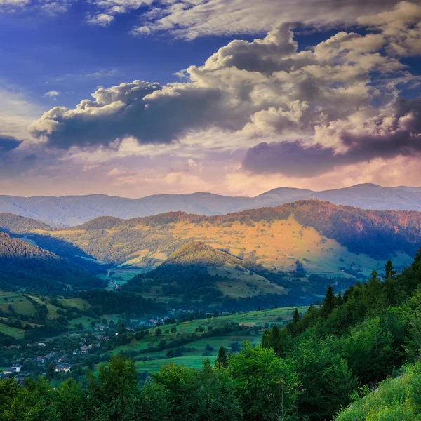 Villaggio sul prato collinare con foresta in montagna al mattino — Foto Stock