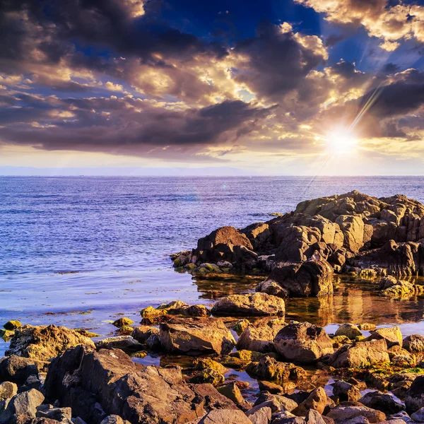 Ola de mar rompe sobre rocas al atardecer —  Fotos de Stock