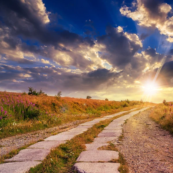 Estrada de lajes de concreto subida ao céu por do sol — Fotografia de Stock