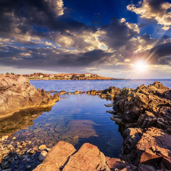 Costa del mar contra la vieja ciudad al atardecer — Foto de Stock