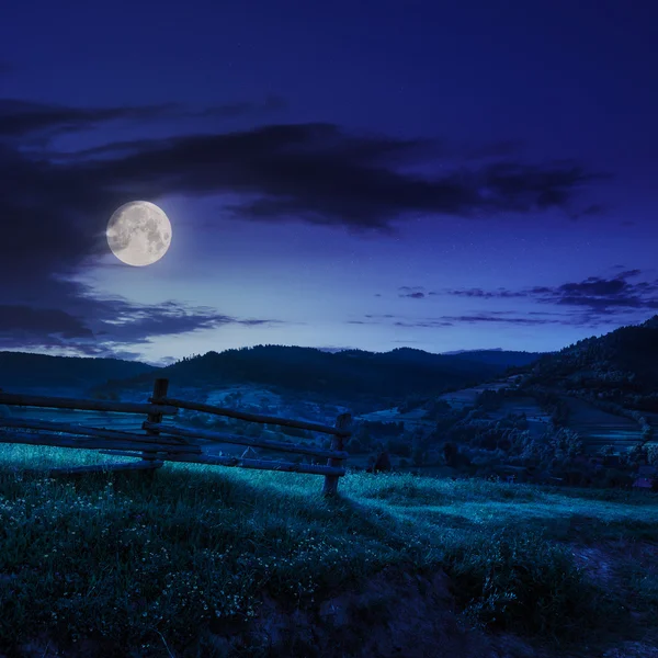 Recinzione di legno nell'erba sul fianco della collina di notte — Foto Stock