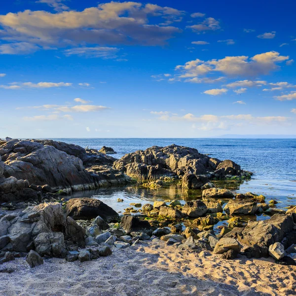 Sea coast with boulders and sand — Stock Photo, Image