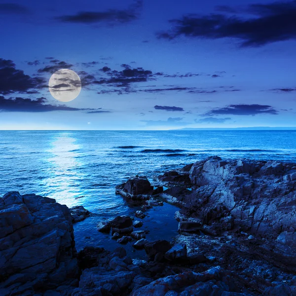 Mar tranquilo con rocas en la costa por la noche — Foto de Stock