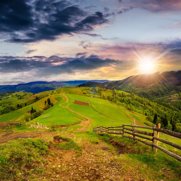 Staket på hillside äng i berg vid solnedgången — Stockfoto