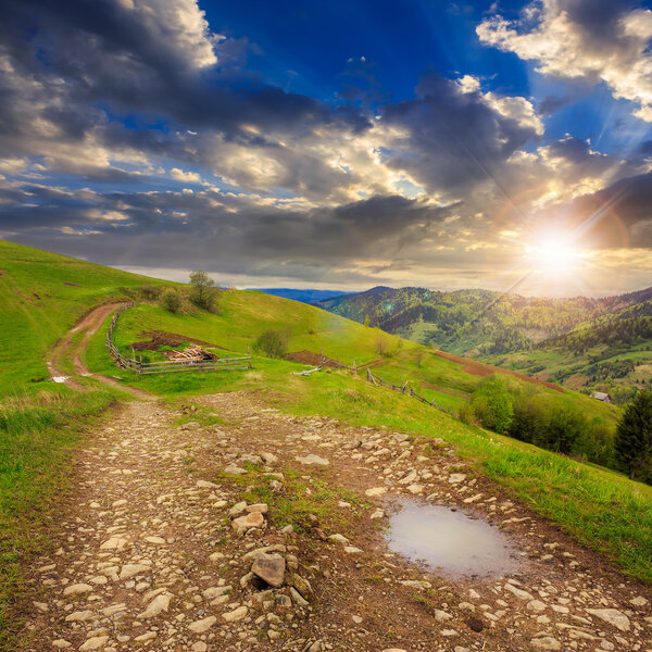 fence on hillside meadow in mountain at sunset