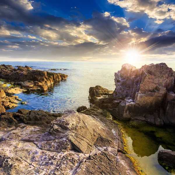 Calm sea wave touches boulders at sunset — Stock Photo, Image