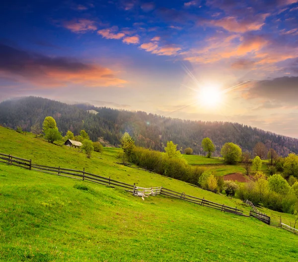 Hillside günbatımında dağ çayır çit — Stok fotoğraf