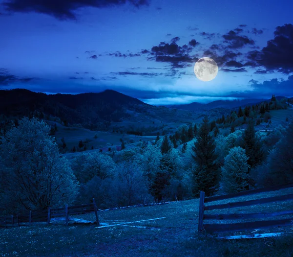 Cerca no prado encosta na montanha à noite — Fotografia de Stock