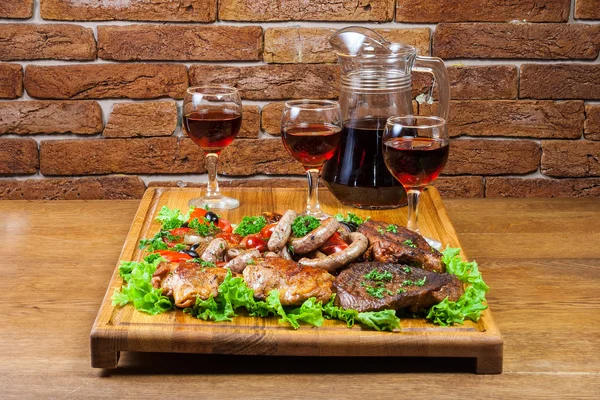 Wine and cold cuts on a wooden board — Stock Photo, Image